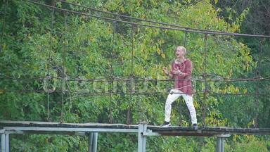 在美丽的<strong>画报</strong>上，一位英俊的金发男子站在河上的吊桥上唱歌